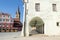 Old, medieval, white building with a corridor with several archways and a church tower in the background, in Sibiu, Romania