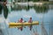 Old men rowing in the lake in yellow kayak with dogs