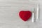 An old mercury thermometer with syringe and red heart on wood background. Medical health care
