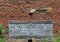 Old metal box in front of weathered brick wall