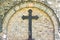 Old metal cross on brick wall background , rusty cross on grave