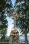 Old metal cross, trees and sky in the background