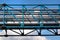Old metal overhead pedestrian footbridge against blue sky