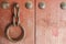 Old metal ring handle on red wooden door