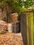 Old metal rusty barrels in the corner of a garden at a wooden fence