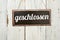 Old metal sign in front of a white wooden wall - german word for closed - geschlossen