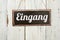 Old metal sign in front of a white wooden wall - German word for Entrance - Eingang