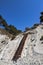 An old metal staircase and massive white rocks on a wild beach