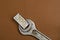 Old metal wrench and bill on a brown background