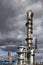 Old methanol distillation rectification refinery column towers and reactors under stormy sky with dark clouds background