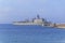 Old military battleship with radar on blue sea docked at marina