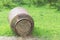 An old milk barrel laying on its side on grass filled with hay