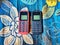 Old Mobile Phone with Texting or SMS Button Keyboard or Keypad on Colorful Flowery Fabric Background