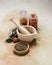 Old mortar and pestle with spices and herbs on softly colored canvas