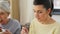 Old mother and adult daughter eating cake at home