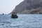 Old motor boat in the sea against the backdrop of mountains, sultry sunny noon