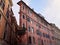 Old narrow dirty pink residential building with round balcony. Rome, Italy