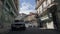 Old narrow streets of Havana, the capital of Cuba. A narrow street between two and three storey buildings, with a parked