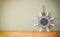 Old nautical wood wheel, anchor and shells on wooden table over wooden background. vintage filtered image