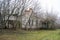 The old, neglected, lordly house and porch among the trees. Texture of old cracked wood painted green.