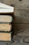 Old and new books arranged in a row, top view of spines, aged wood background, school, education, learning, reading concept