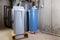 Old and new water softener tanks in a utility room