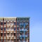 Old New York City apartment building exterior with fire escapes and windows and empty blue sky above