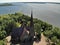 Old nice catholic church. long Pier breakwater cutwater in lake or sea. Summer