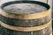 Old oak barrel dark brown with copper iron hoops closeup distillery background