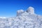 The old observatory covered with textured snow. Winter scenery. Beautiful landscape of high mountains and blue sky. Lawn covered