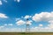 Old oil and gas rig profiled on blue sky with white clouds, in spring