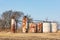 Old oil well storage tanks in farm field.