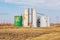 Old oil well storage tanks in farm field.