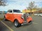 Old orange 1934 Ford V8 model 40 coupe 5 window street rod in a parking lot. Classic car show