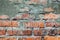 Old orange brick wall with cement patch and cracks