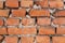 Old orange brick wall, uneven masonry close up