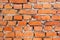 Old orange brick wall, uneven masonry. close up