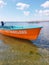 An old orange rescue boat in the sea near the shore anchored with the inscription rescue in Ukrainian on the deck.
