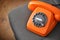 Old orange telephone with dial