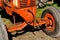 Old orange tractor with crank and a wide front