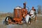 An old orange tractor sits in the snow