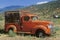 An old, orange truck rests abandoned in a Colorado field, Snowmass, Colorado