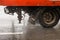 old orange utility truck moving on asphalt road under rainy day - close-up