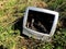 An old and out of date computer monitor that has been dumped in wasteland in a fly tipping or waste concept image