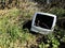 An old and out of date computer monitor that has been dumped in wasteland in a fly tipping or waste concept image