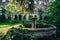 Old overgrown round broken fountain near ruins of abandoned mansion