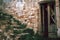 Old Overgrown Staircase, Crumbling Brick Wall and Abandoned Wooden Door in Craco, Italy