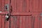 Old padlock on rustic red wooden door