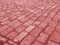 Old paving stones in perspective closeup. Red background.