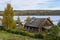 Old peasant house on the shore of forest lake